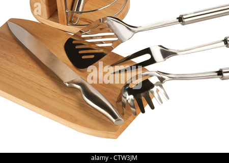 Silberne Küchenutensilien inklusive Schneebesen, Tong und Löffel auf einem weißen Hintergrund und Messer-set Stockfoto