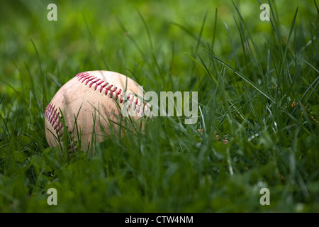 Einem alten und abgenutzten Hardball oder Baseball im grünen Gras. Stockfoto