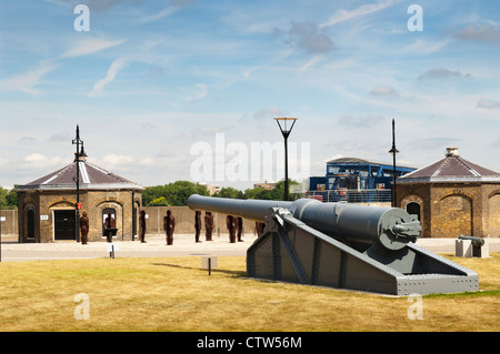 Anzeige der Kanonen an Royal Arsenal Fluss, mit der "Montage, Edition 1" Installation von Peter Burke im Hintergrund. Stockfoto