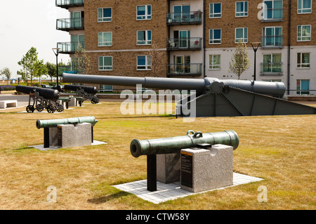 Anzeige der Kanonen im Royal Arsenal Riverside mit modernen Wohngebäude im Hintergrund. Stockfoto