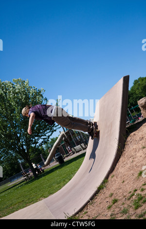 Lauffeuer eines Skateboarders hinauf ein konkretes Skateboard Rampe an der Skate-Park. Stockfoto