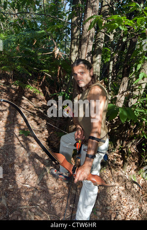 Bogenschütze mit Elfen Ohren posiert im Wald Stockfoto