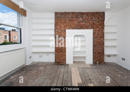 Zimmer mit weißen Wänden und gemauerten Schornstein renoviert. Stockfoto
