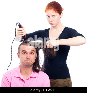 Ernst Friseur Frau rasieren lustigen langhaarigen Mann mit Haarschneidegerät, isoliert auf weißem Hintergrund. Stockfoto