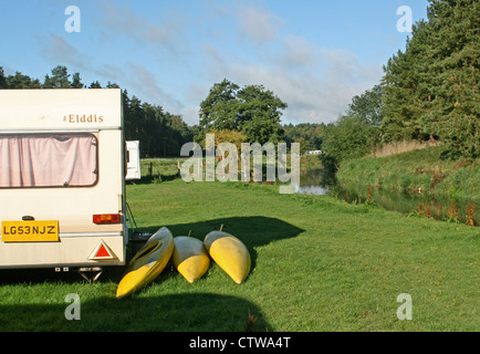 Wohnwagen und Kanus in Thetford Forest, neben dem Flüsschen Ouse, kleine Lodge Bauernhof camping, Downham, Brandon, Suffolk Stockfoto