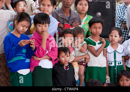 Myanmar, Burma. Bagan. Kinder beobachten einen Nat Pwe Leistung, eine Zeremonie, um die Geister für ein Jahr Glück zu bedanken. Stockfoto