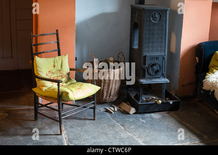 Kaminofen und einen Korb von Protokollen in der vorderen Zimmer von einem englischen Cottage. Großbritannien Stockfoto