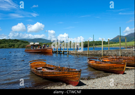 Touristen auf eine Fähre mit Ruderbooten im Vordergrund auf Derwentwater, Keswick im Lake District, Cumbria Stockfoto