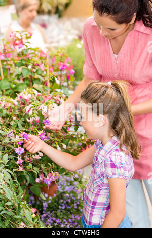 Kleines Mädchen mit Mutter suchen Blumen im Botanischen Garten Stockfoto