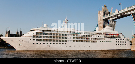 Der Silver Cloud Kreuzfahrtschiff unterquert die Tower Bridge mit Hilfe von einem Schlepper an einem hellen Sommertag Stockfoto