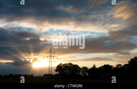 Strommasten gegen einen schönen gelb-orange-Sonnenuntergang Stockfoto