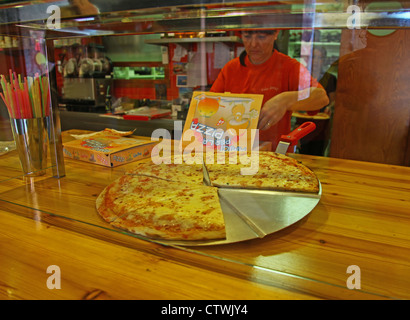 Eine Arbeitnehmerin Shop setzen eine Take away Pizza in einer box Stockfoto