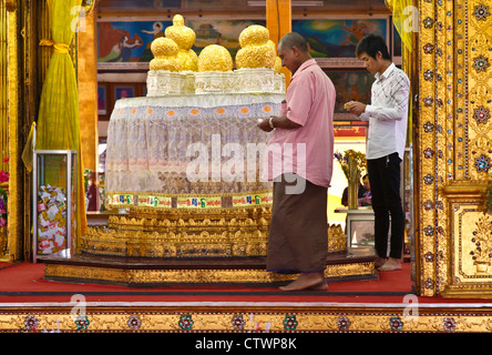 Männer legen Blattgold auf dem zentralen Reliquiar in den Tempel der PHAUNG DAW OO PAYA einer buddhistischen Website im SHAN-Staat - INLE-See, MYANMAR Stockfoto