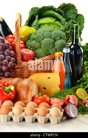 Lebensmittel im Weidenkorb, einschließlich Gemüse, Obst, Backwaren und Milchprodukte und Wein isoliert auf weiss Stockfoto