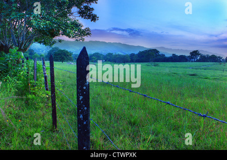 Sommer Weide Zaun mit Abendhimmel, Berge. Stockfoto