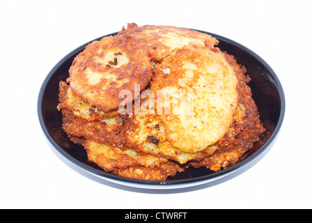 Kleine Kartoffelpuffer auf der schwarzen Platte Stockfoto