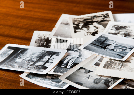 Haufen alter schwarz-weiß Familienfotos auf einem Tisch Stockfoto