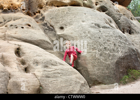 kleiner Junge klettern einen Felsen in der Nähe von Bad Schandau, Sächsische Schweiz, Sachsen, Deutschland Stockfoto