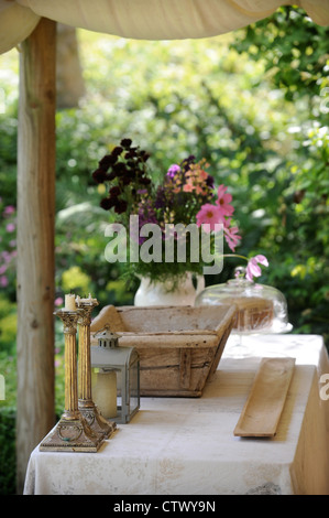 Glas Kerzen und Blumen auf einem Tisch UK Stockfoto