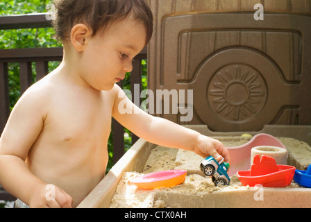 Ein Junge spielt in einer Sandbox. Stockfoto