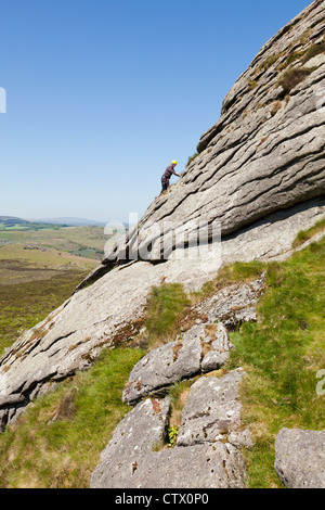 Mann, Klettern auf Haytor Rocks, eine Granit-Tor auf Dartmoor, Devon, UK Stockfoto