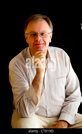 Porträt eines Mannes auf einem schwarzen Hintergrund, Studio gedreht. Stockfoto