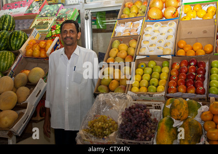 Obst und Gemüse-Händler in seinem Shop auf dem grünen Markt in Sharjah, Vereinigte Arabische Emirate Stockfoto