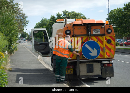 Des Rates Arbeiter Entwässerung Barrel Gulley Reiniger in die Straße Kanalisation Stockfoto