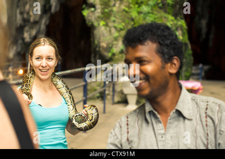Kaukasische Frau Tourist posierte mit Schlange in Batu Höhle, Kuala Lumpur, Malaysia. Stockfoto