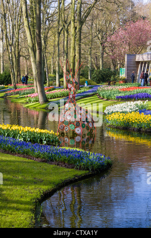 Frühlingsgartenlandschaft mit Tulpen und Narzissen, die sich im See der Keukenhof Gardens, Südholland, Niederlande, widerspiegelt. Stockfoto