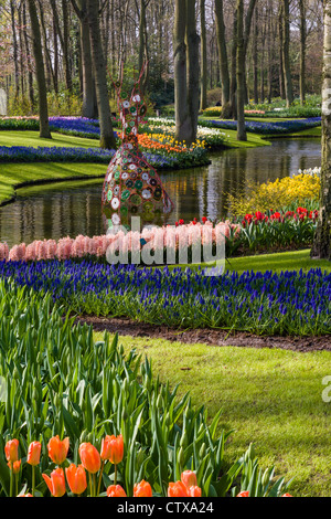 Frühlingsgartenlandschaft mit Tulpen, Muskari, Hyazinthe und Narzissen, die sich im See in den Keukenhof-Gärten, Südholland, Niederlande, widerspiegeln. Stockfoto