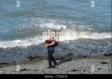 Man spielt Dudelsack am Strand von Clarach Bucht in der Nähe von Aberystwyth in Wales Stockfoto