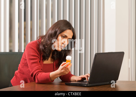 Geschäftsfrau, die Medizin auf Computer nachschlagen Stockfoto