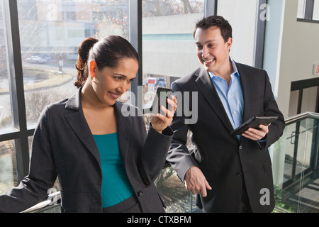 Business-paar im Büro Blick auf Tablets und Smartphones Stockfoto