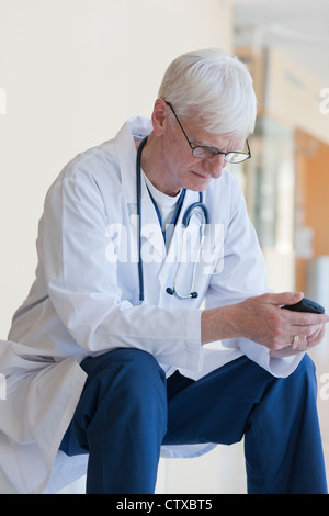 Arzt eine SMS auf dem Handy lesen Stockfoto