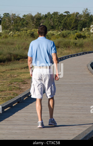 Besucher wandern ein Holzsteg durch Sumpfgebiet in der Nähe von Cameron Prairie National Wildlife Refuge Visitor Center, LA, USA Stockfoto