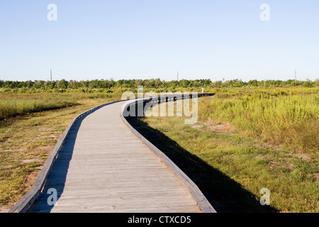 Besucher wandern ein Holzsteg durch Sumpfgebiet in der Nähe von Cameron Prairie National Wildlife Refuge Visitor Center, LA, USA Stockfoto