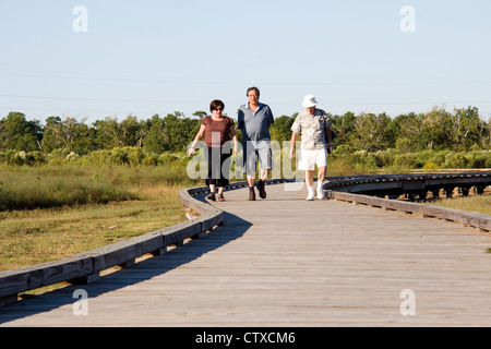 Besucher wandern ein Holzsteg durch Sumpfgebiet in der Nähe von Cameron Prairie National Wildlife Refuge Visitor Center, LA, USA Stockfoto