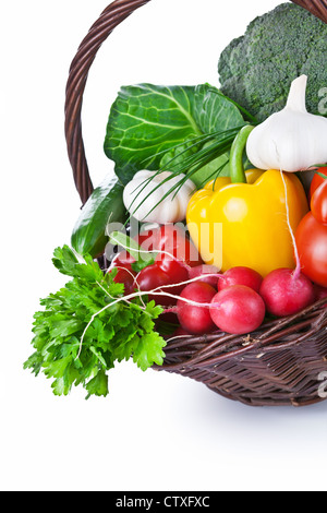 Komposition mit rohem Gemüse in einem Weidenkorb. Isoliert auf weißem Hintergrund Stockfoto