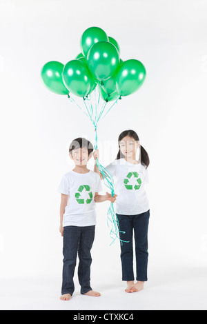 Kinder tragen recycling Hemd mit grünen Luftballons Stockfoto