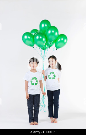 Kinder tragen recycling Hemd mit grünen Luftballons Stockfoto