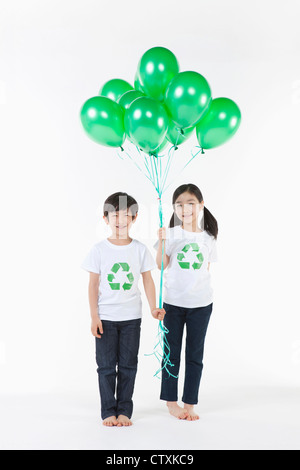 Kinder tragen recycling Hemd mit grünen Luftballons Stockfoto