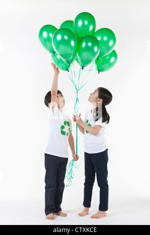 Kinder tragen recycling Hemd mit grünen Luftballons Stockfoto