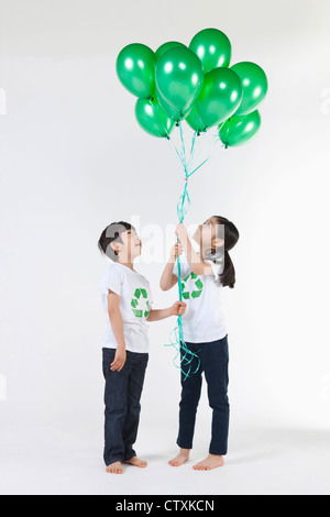 Kinder tragen recycling Hemd mit grünen Luftballons Stockfoto