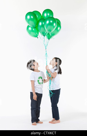 Kinder tragen recycling Hemd mit grünen Luftballons Stockfoto