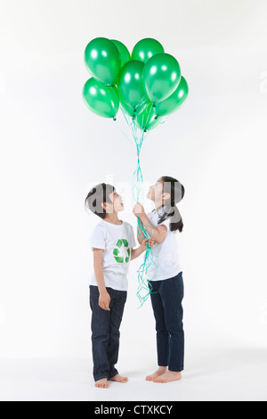 Kinder tragen recycling Hemd mit grünen Luftballons Stockfoto