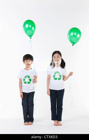 Kinder tragen recycling Hemd mit grünen Luftballons Stockfoto