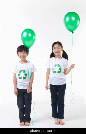 Kinder tragen recycling Hemd mit grünen Luftballons Stockfoto