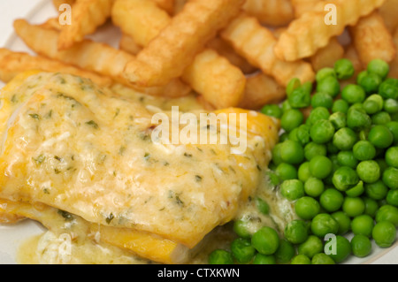 Die freche Fisch Co. Davidstow Cheddar und Schnittlauch Sauce auf geräucherter Schellfisch, Chips und Erbsen Stockfoto