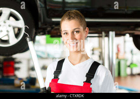 Reifer Mann - Client- und junge weibliche Kfz-Mechaniker sucht unter Auto-Haube Stockfoto